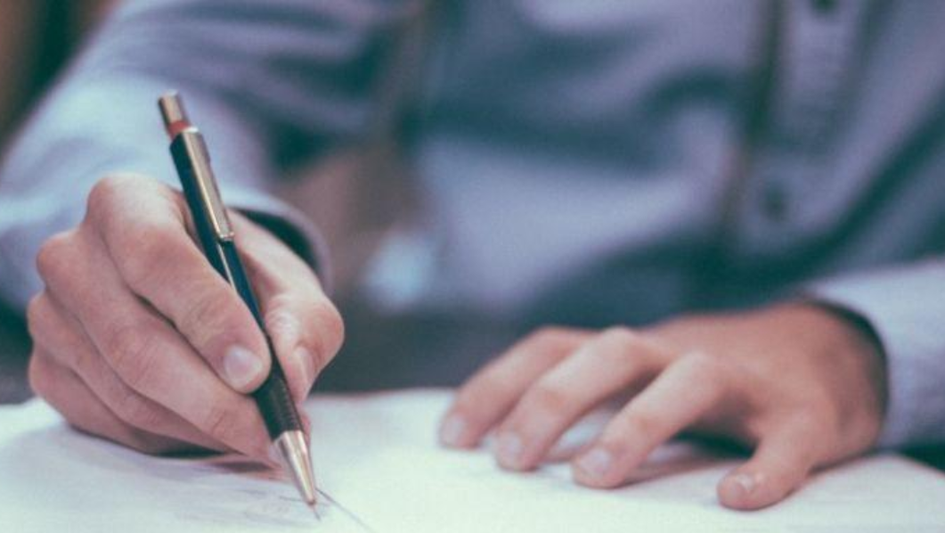 mani con penna che compilano modulo