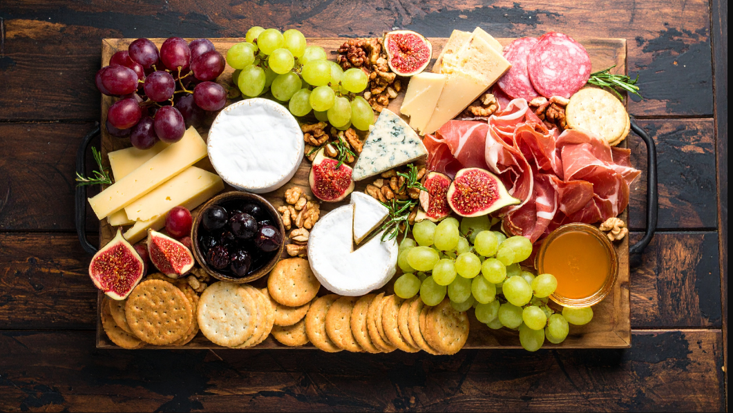 immagine di un tagliere con salumi, formaggi e varia frutta