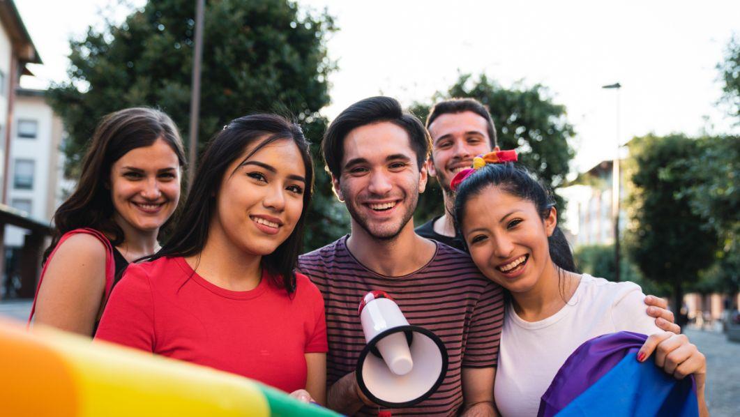 Un gruppo di ragazzi e ragazze con megafono durante una manifestazione LGBTQIA+
