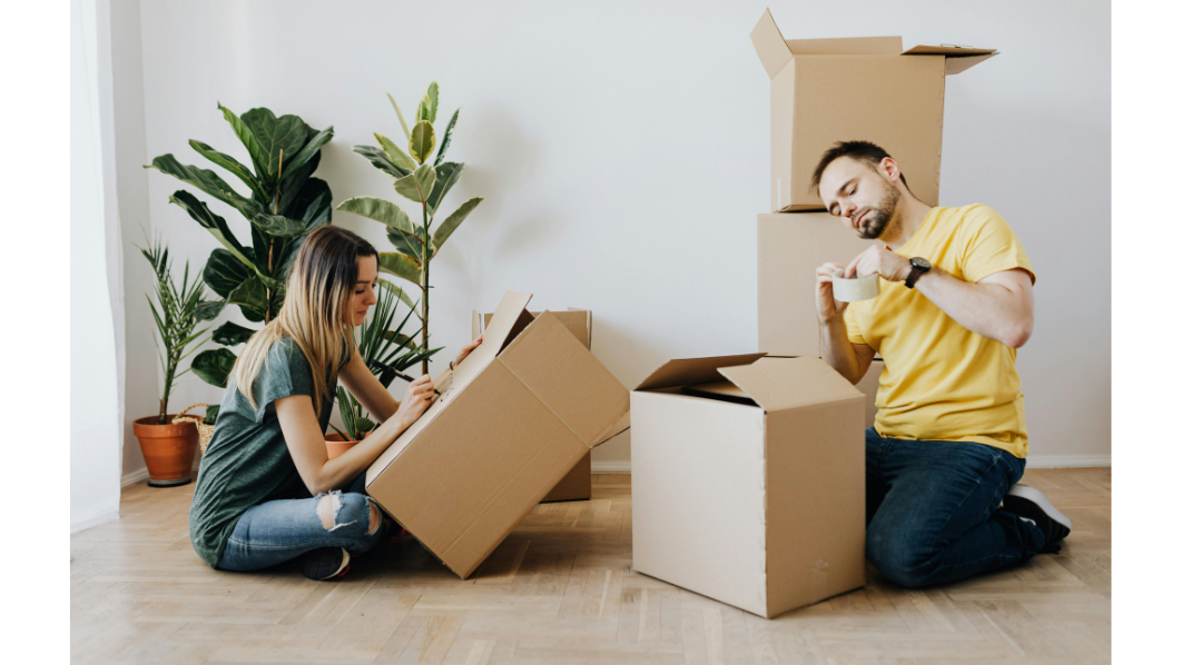 Una ragazza e un ragazzo con scatoloni