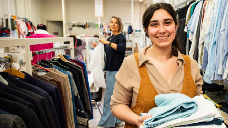 mercatino Abito con due donne che tengono in mano degli indumenti