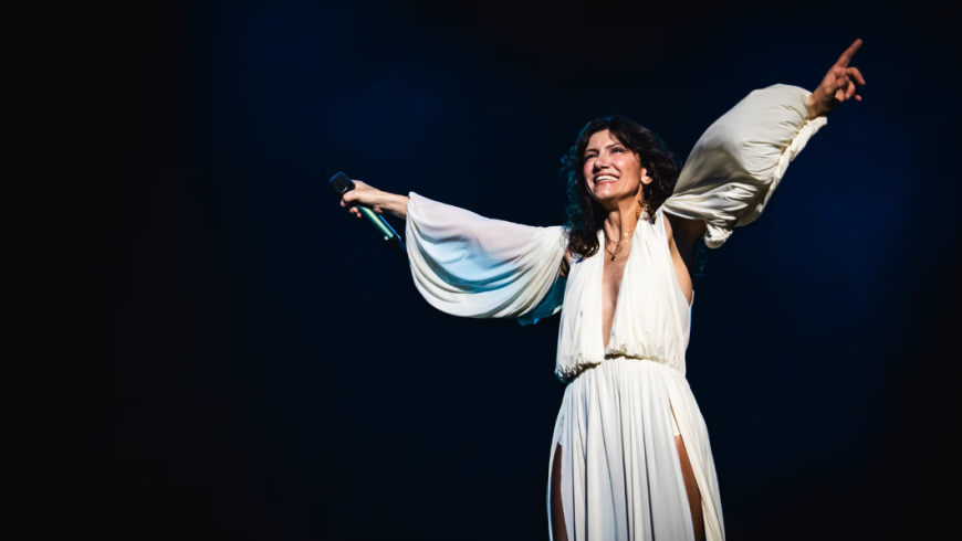 Elisa in abito bianco su sfondo nero