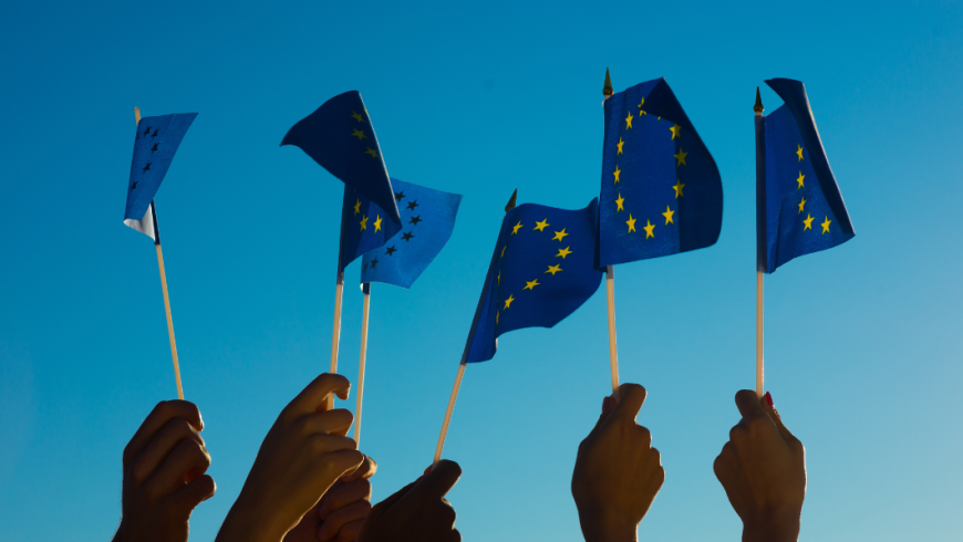 Mani che tengono bandierine Europa