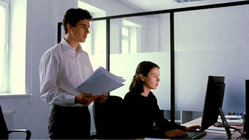 impiegati, uomo e donna, in un ufficio, davanti al pc