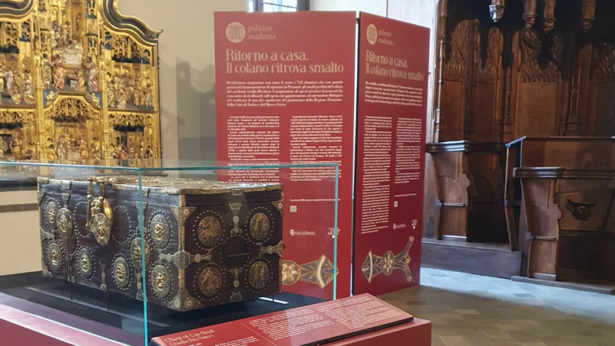 Sala di Palazzo Madama con una pala dorata a muro, un baule, cartelli e cantoria di legno