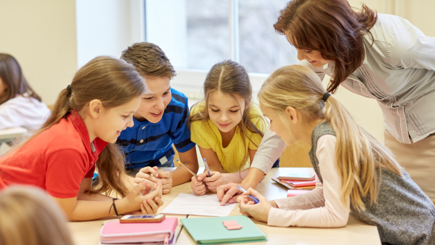 gruppo di bambini che studia accompagnato da una donna adulta