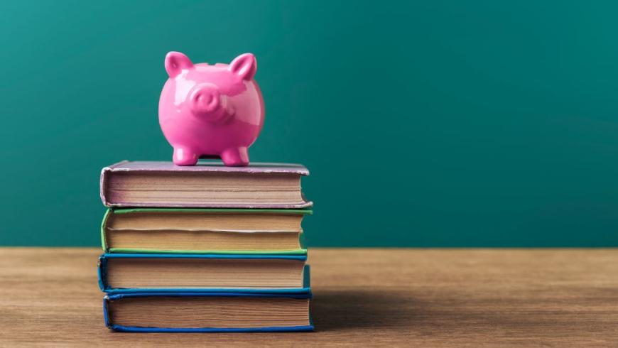 Salvadanaio sopra una pila di libri