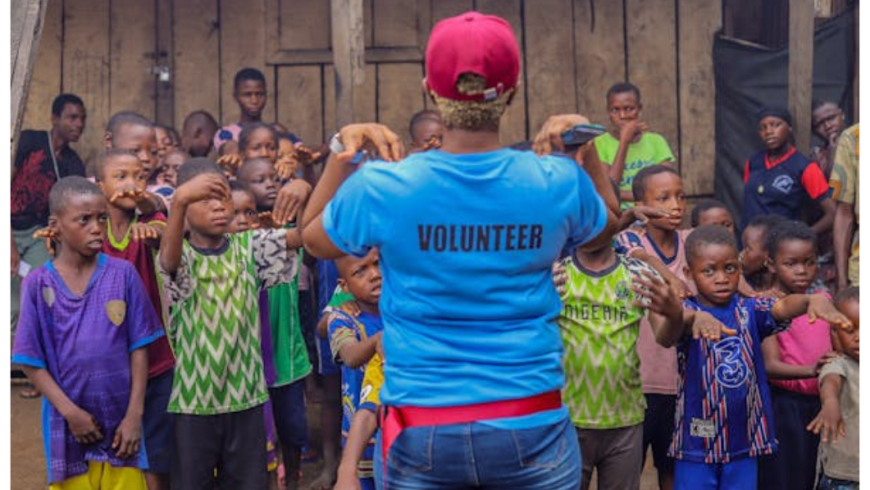 foto di un grupo di bambini africani e di un volontario