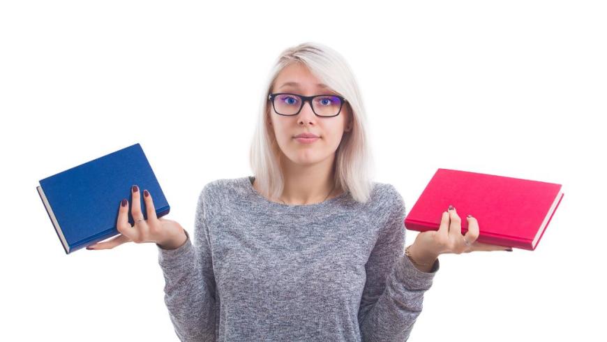 Ragazza indecisa con due libri in mano