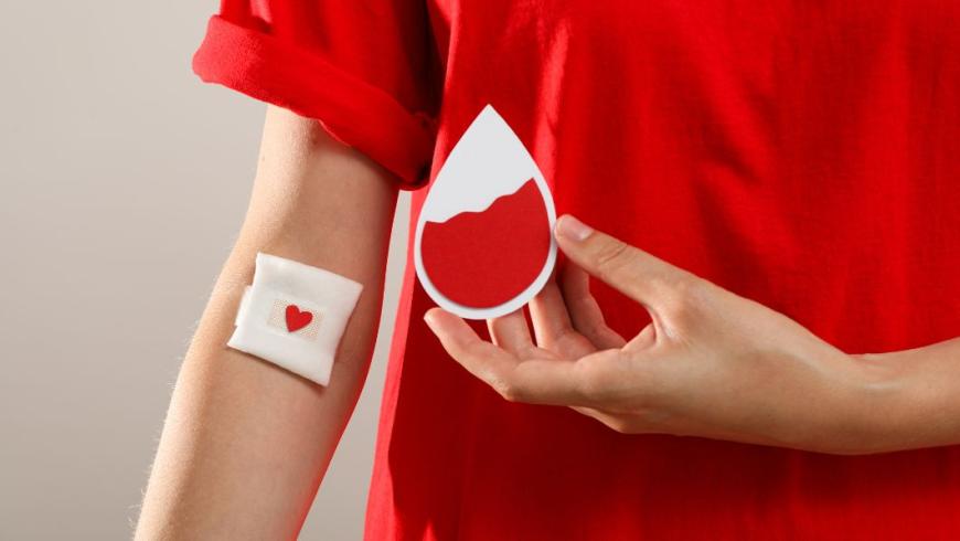 rappresentazione della donazione di sangue: persona con maglietta rossa e cerotto al braccio