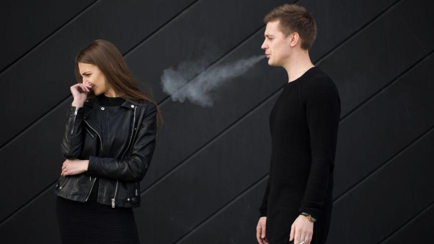 ragazza infastidita dal fumo di un ragazzo