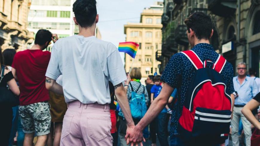due ragazzi si tengono per mano al pride di Torino