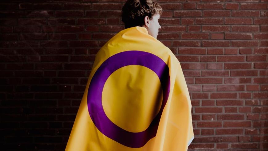 ragazzo con addosso bandiera intersex 