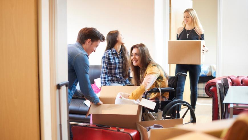 gruppo di ragazze e ragazzi fanno il trasloco presso una residenza temporanea