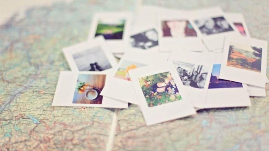 cartoline e fotografie posate sopra una mappa stradale