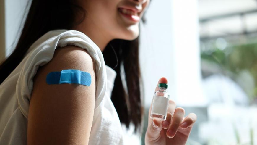 ragazza sorridente che mostra il braccio dove ha appena ricevuto il vaccino