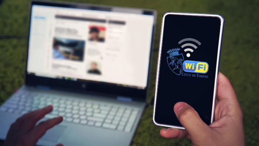 persona con pc e smartphone si collega alla rete wifi della città di torino