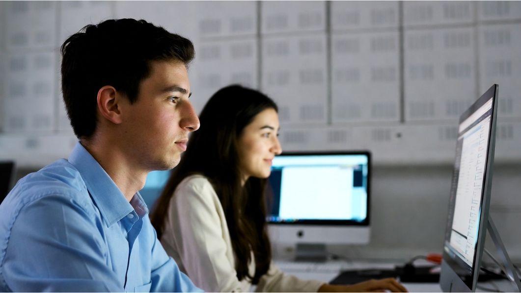 giovani impiegati (uomo e donna) in ufficio davanti al pc